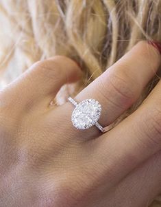 a woman's hand with a diamond ring on it