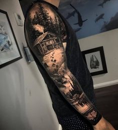 a man's arm with a house and trees on it