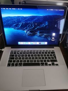 an open laptop computer sitting on top of a wooden desk