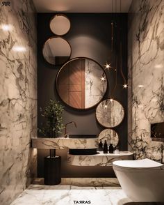 a bathroom with marble walls and round mirrors