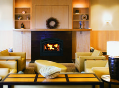 a living room filled with furniture and a fire place in the middle of it's wall