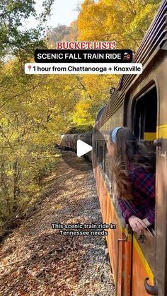 a woman is looking out the window of a train as it travels through autumn foliage