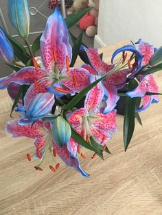 pink and blue flowers in a vase on a table