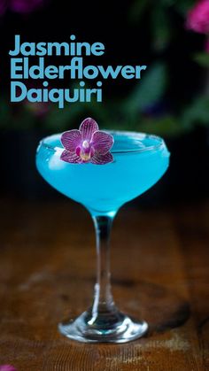 a blue drink with a flower on the rim in front of purple flowers and text that reads, jasmine elderflower daiquiri