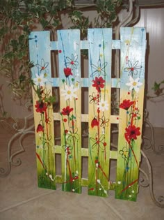 a painted wooden fence with flowers on it