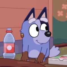 a cartoon dog sitting on top of a wooden table next to a bottle of water