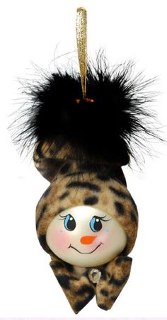 a cat ornament hanging from a string with a black hair on it's head