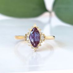 An extraordinary Contemporary Art Deco Marquise Shaped Alexandrite Engagement ring set in 14K gold enveloped in dynamic shapes of diamonds, classy and unique for that special somebody. Pictures don't do this ring justice! Only one ring in 14k Yellow gold is in stock. Check out Instagram page for more photos of this ring in different metal and stone: https://www.instagram.com/p/Bt60PmMFuEJ/ ♦ Main Ring Information ♦ Center Stone: Chatham alexandrite, Marquise Faceted Cut, 10x5mm, Green to purple( Marquise Engagement Ring Gemstone, Elegant Marquise Ruby Ring, Exquisite Marquise Diamond Ring, Exquisite Marquise Diamond Ring With Gemstone, Elegant Marquise Ruby Ring With Halo Setting, Elegant Marquise Rings For Proposal, Wedding Yellow Gold Diamond Ring With Gemstone Accents, Elegant Marquise Ruby Ring Gift, Elegant Marquise Ruby Ring As Gift