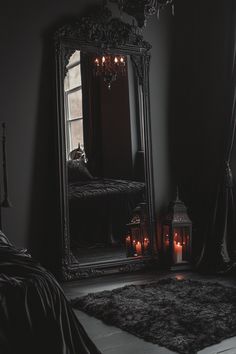 a bedroom with a large mirror and candles on the floor