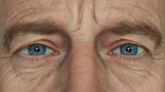 an older man's blue eyes are shown in this close - up photo from the side