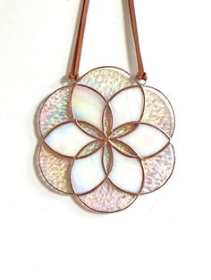 a white and brown flower shaped purse hanging on a wall