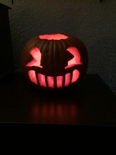 a carved pumpkin with the shape of a person's head on it, sitting on a table