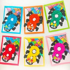 four different colored paper cut outs in the shape of flowers and spider's webs