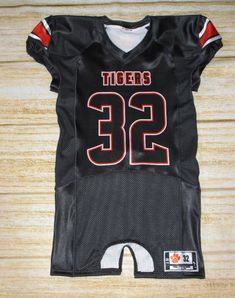 a black jersey with the number 32 on it is laying on a wooden surface,