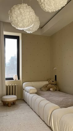 a bed room with a neatly made bed and two teddy bears hanging from the ceiling