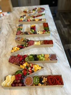 several trays filled with different types of fruit on a counter top next to each other