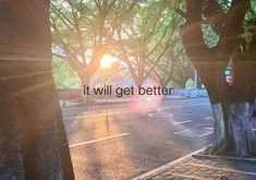 the sun shines through trees on a city street