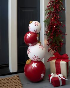 a stack of christmas balls sitting on top of a pile of presents next to a door