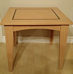 a small wooden table sitting on top of a hard wood floor