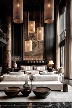 a large living room with black walls and white couches, chandeliers and art work on the wall