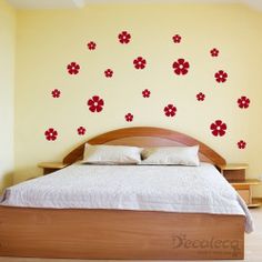 a bed sitting in a bedroom next to a wall with red flowers on it