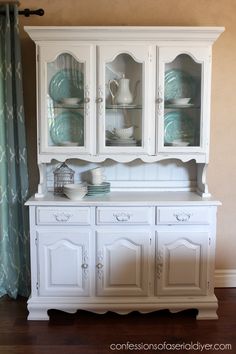 a white china cabinet with glass doors