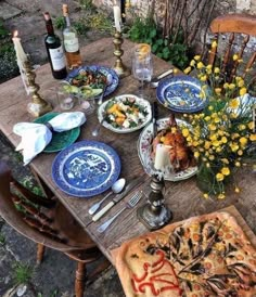 the table is set with plates, silverware and flowers