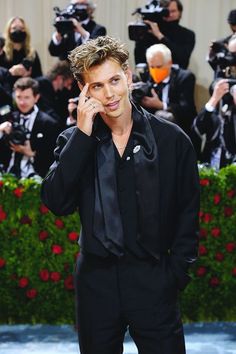 a man in a black suit talking on a cell phone