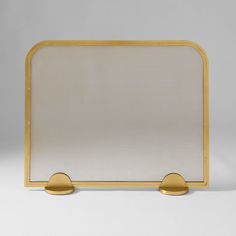 a gold metal frame with two round knobs on each side and a white background