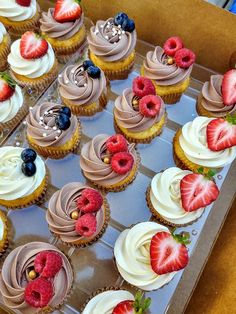 cupcakes with white frosting and strawberries on top