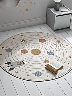 a white rug with planets and stars on the floor in a child's room