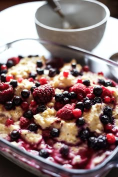 a casserole dish with berries and cream in it