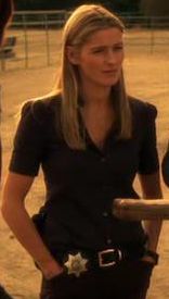 a woman holding a baseball bat standing next to another woman in a black shirt and skirt