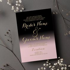 a black and pink wedding card with gold foil on it next to some baby's breath flowers