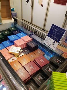 there are many different colored boxes on the display case at this store, and one is for sale