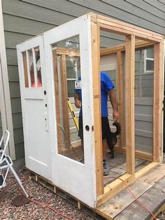 a man is working on the side of a house that's being built with wood