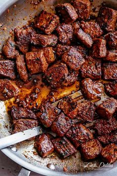 a pan filled with cooked meat on top of a table