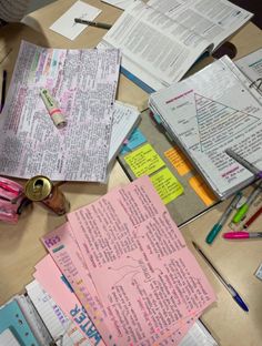 many papers are spread out on a table with pens and pencils next to them