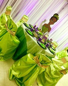 the table is set up with green cloths and purple draping on it