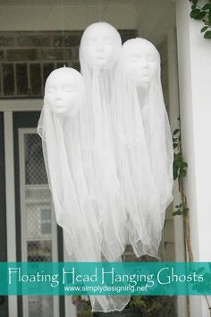 three white mannequin heads hanging from the side of a house with text overlay reading floating head hanging ghosts