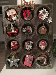 a christmas display made out of an old metal tray with magnets and ornaments on it