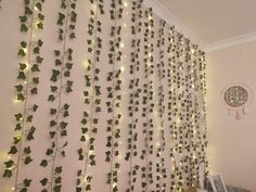 there is a wall covered with green ivy vines and lights hanging from it's sides