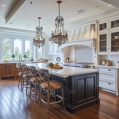 a large kitchen with an island and chandelier hanging from it's ceiling