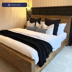 a large bed with black and white pillows on it's headboard in a bedroom