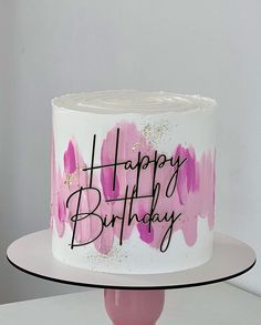 a white and pink birthday cake with the words happy birthday written on it's side