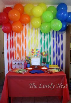 a red table topped with a cake and balloons