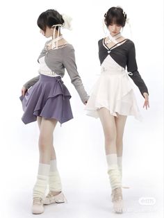 two young women dressed in short skirts and sweaters