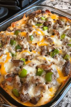 a casserole dish with meat, cheese and green peppers