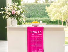 a pink towel sitting on top of a counter next to a vase filled with flowers