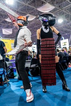 two people dressed up in costumes with chainsaws on their heads and one person wearing a helmet